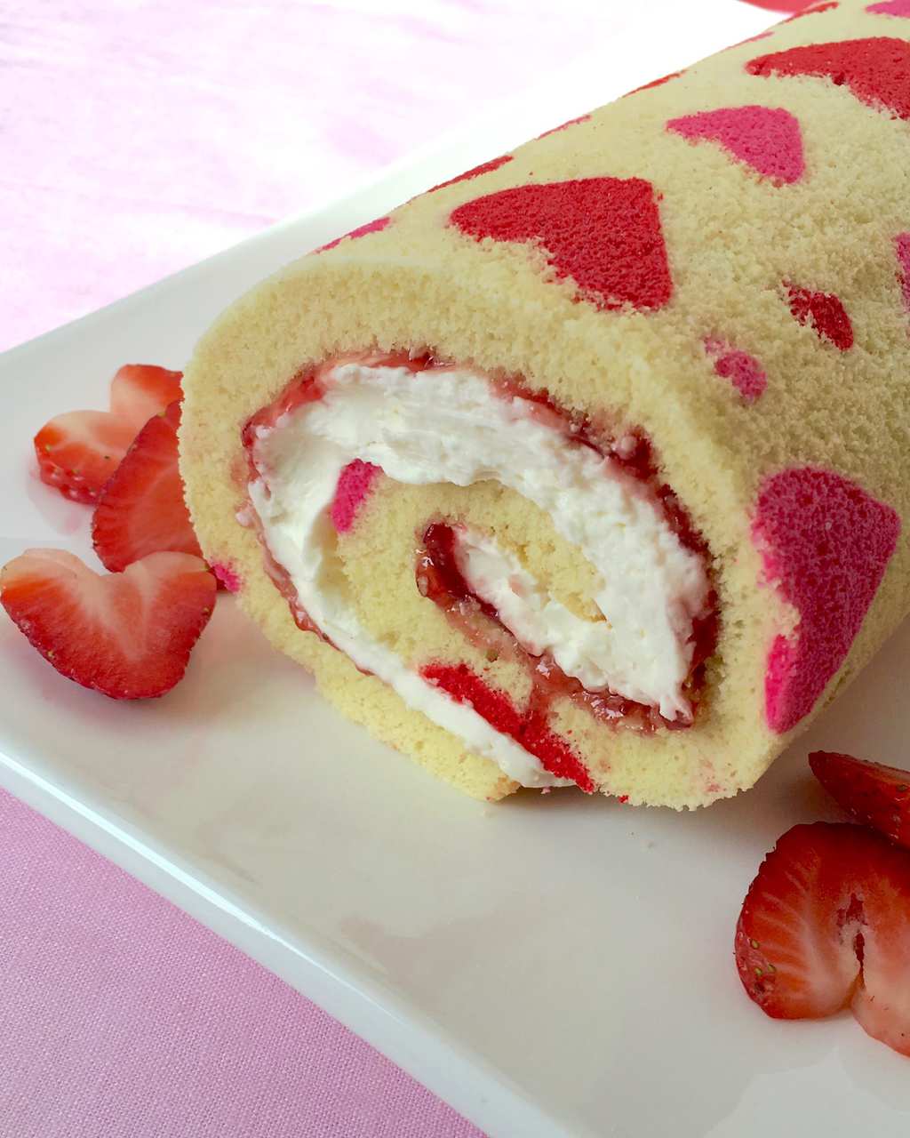 A rolled valentine's day cake filled with cream cheese and strawberry filling.