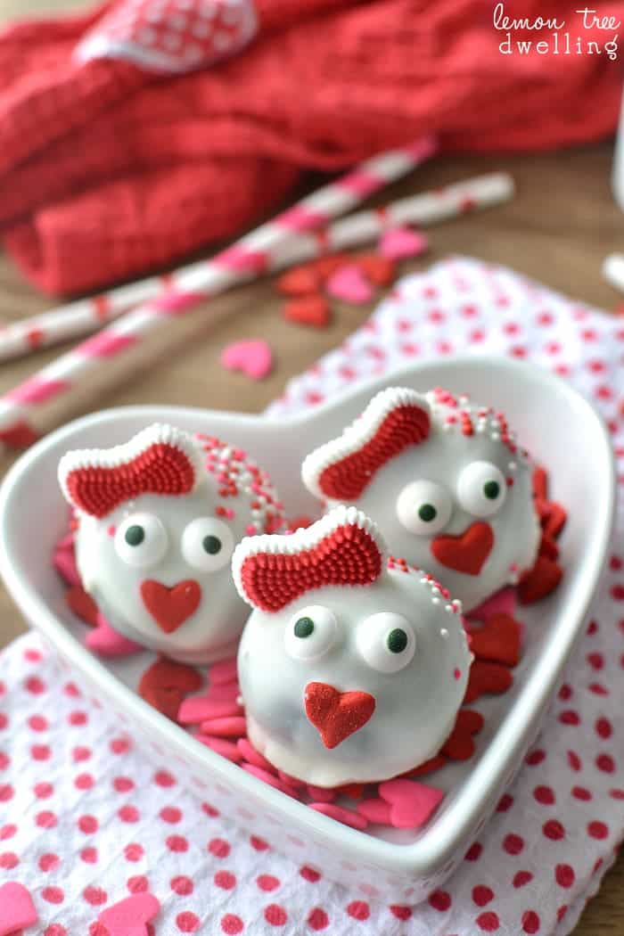 Three love bug oreo truffles in a heart shaped bowl.