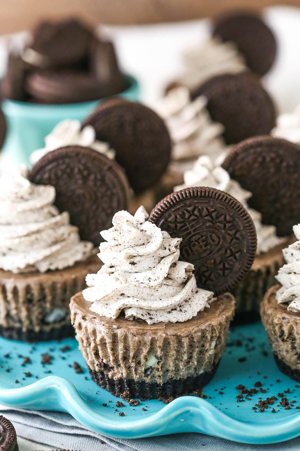 No bake mini cheesecakes on a serving platter near a bowl of Oreos.