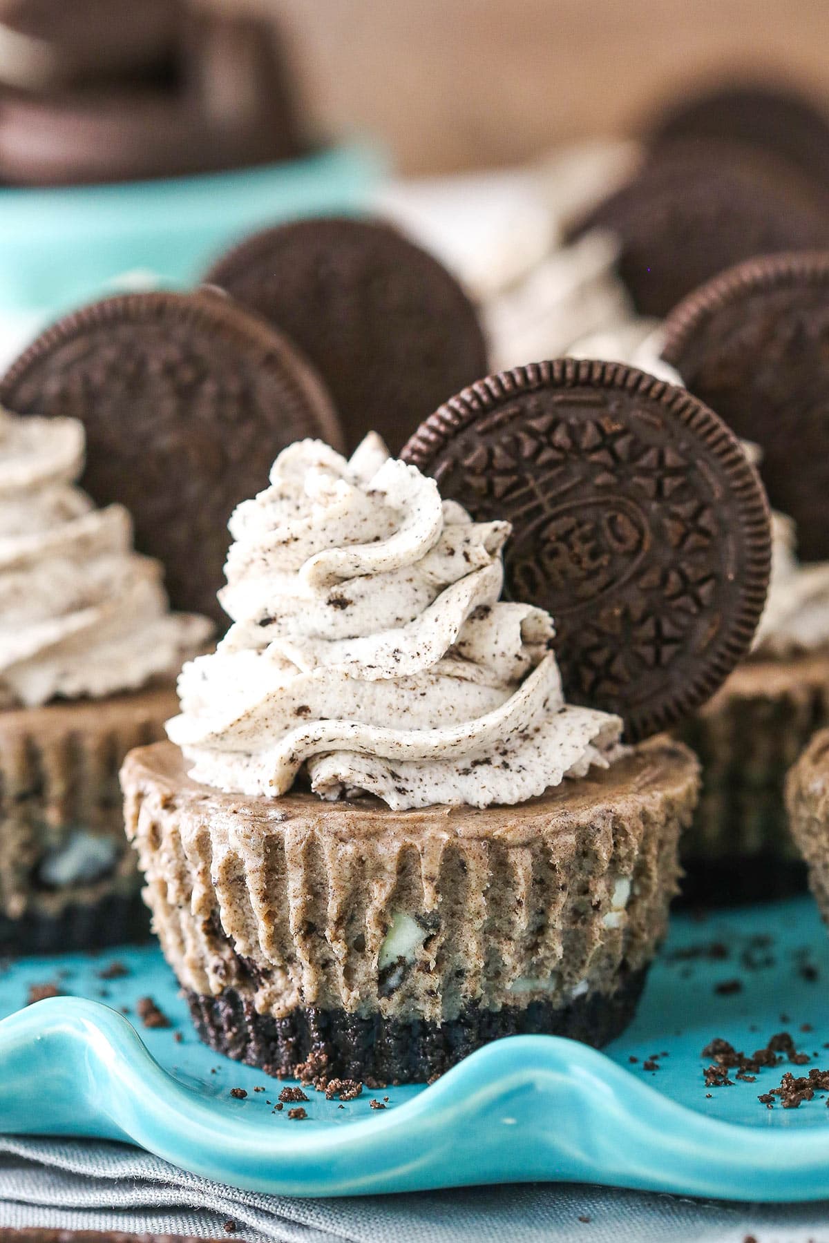 Oreo cheesecakes on a serving platter near a bowl of Oreos.