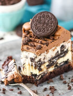 Ultimate Oreo cheesecake on a plate with a fork taking a piece out of it.