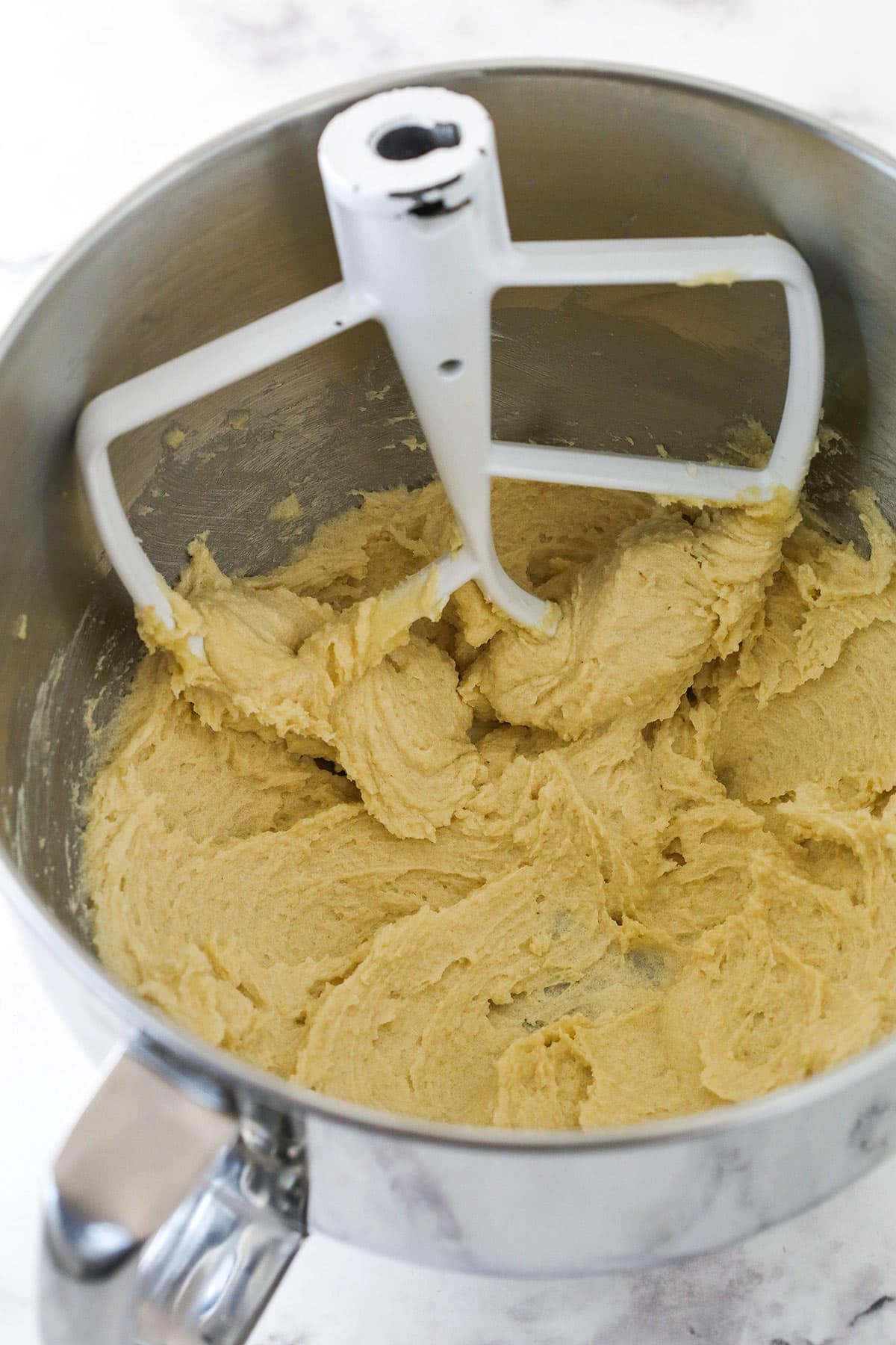 Creaming butter and sugar for white chocolate chip cookies.