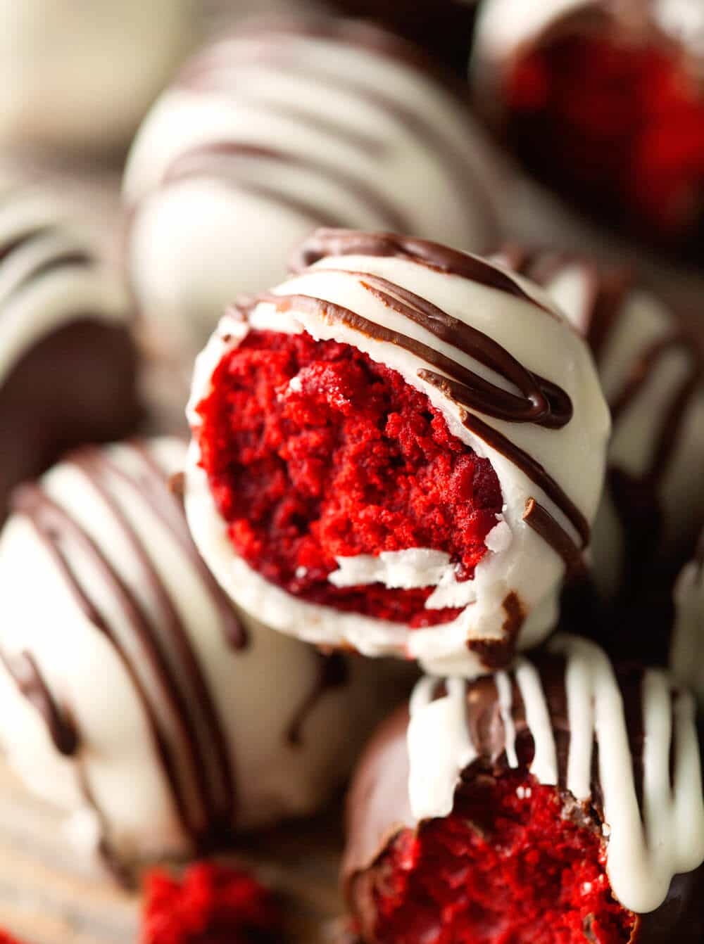 Close up of red velvet cake truffles with a bite take from the top 2 truffles.