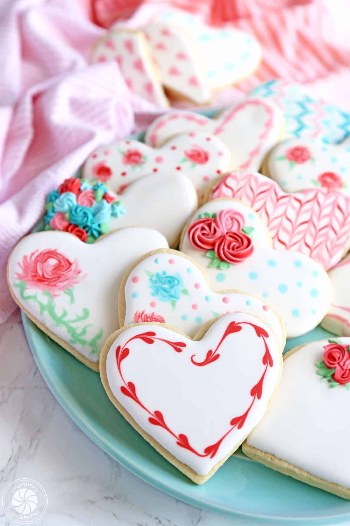 A plate of pretty heart-shaped sugar cookies with royal icing.