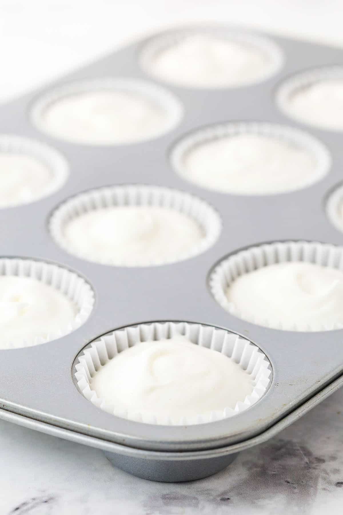 Unbaked angel food cupcake batter in a tin next to a photo of baked cupcakes.