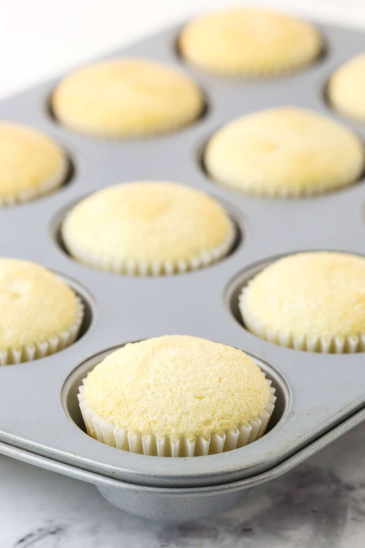 Unbaked angel food cupcake batter in a tin next to a photo of baked cupcakes.