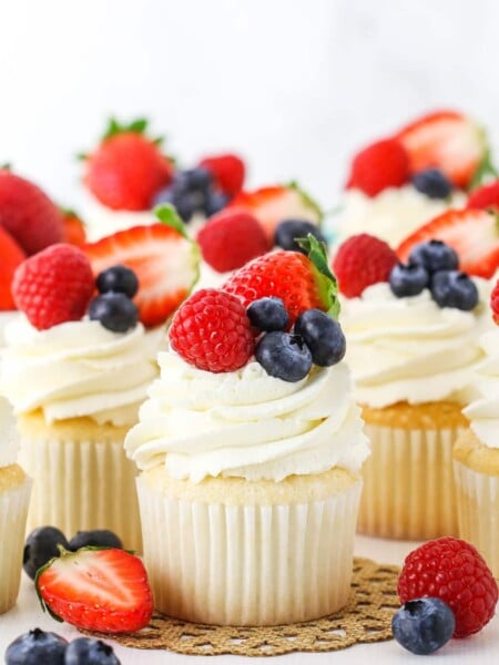 Angel food cupcakes topped with whipped cream and fresh berries.