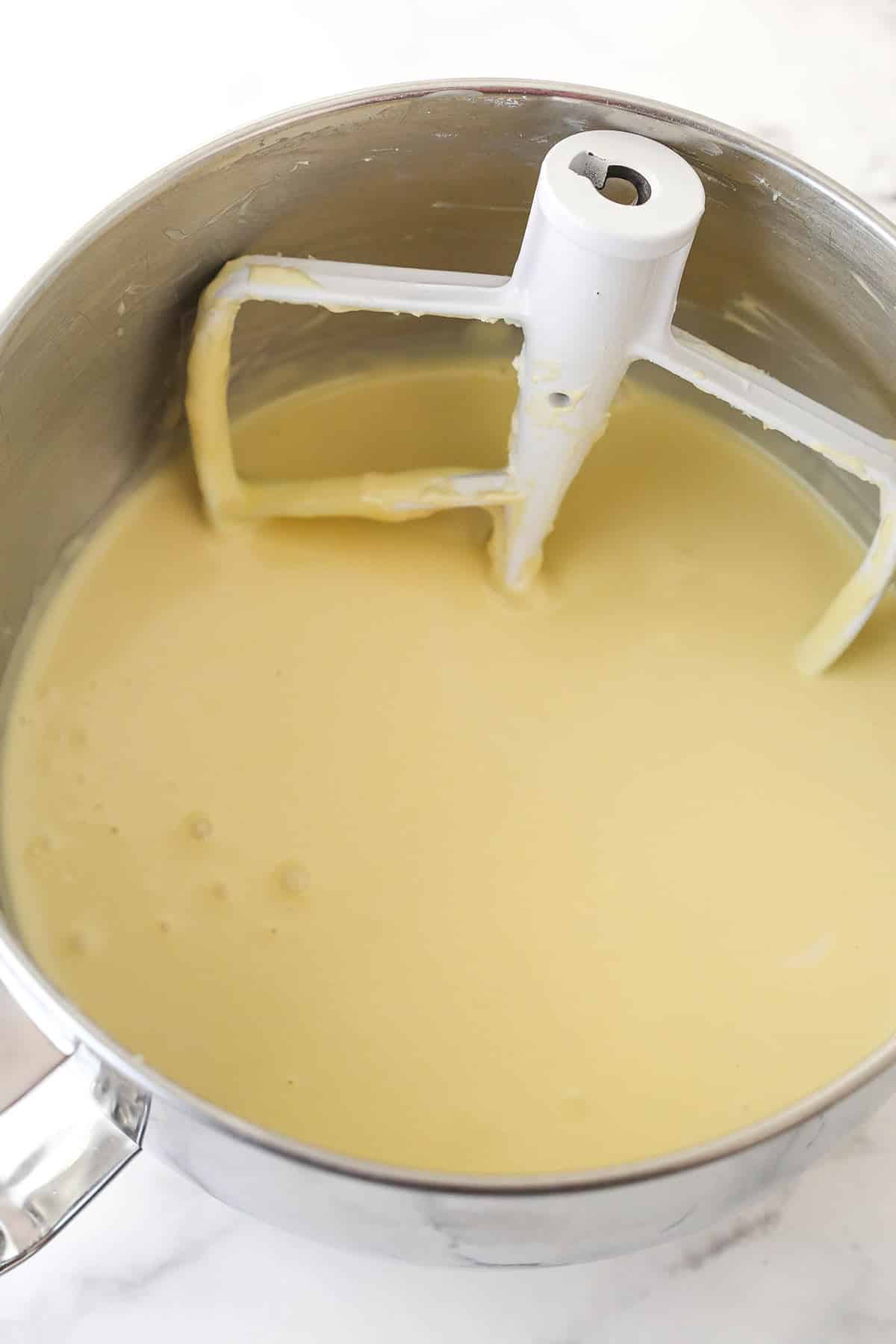 Mixing eggs into cheesecake filling.