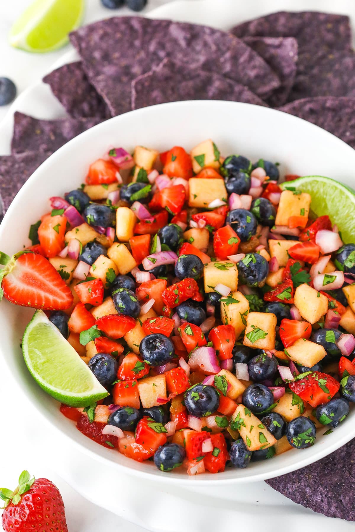 This Berry Fruit Salsa is made with strawberries, blueberries and apples! It has amazing flavor, makes a wonderful appetizer or snack and is naturally red, white and blue - perfect for July 4th! close up of berry fruit salsa in white bowl