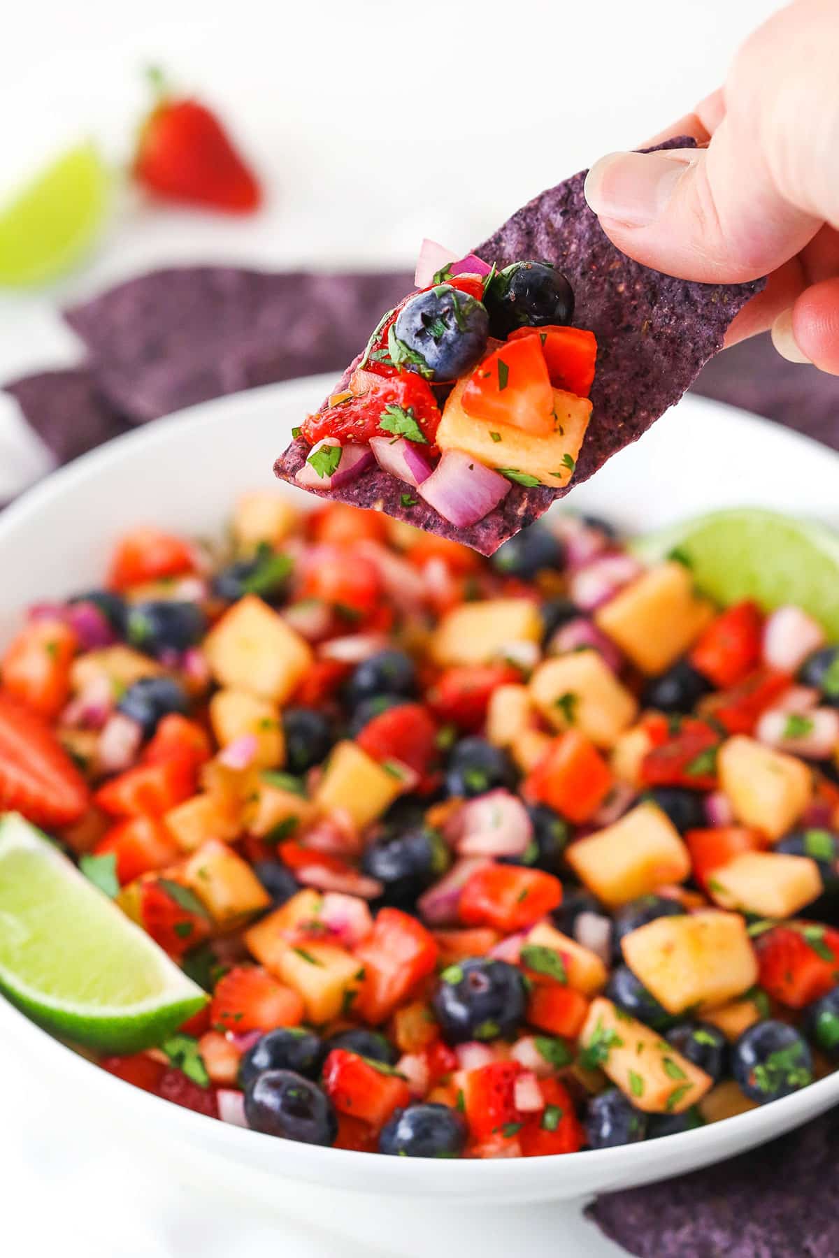 berry fruit salsa scooped onto blue tortilla chip