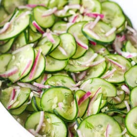 Homemade cucumber onion salad with dill and vinegar in a bowl.