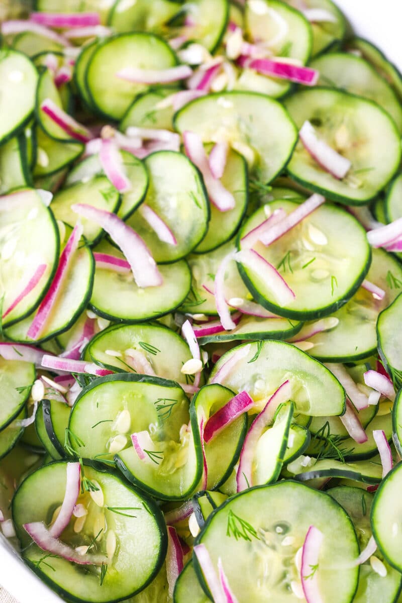 close up of cucumber salad in a white dish