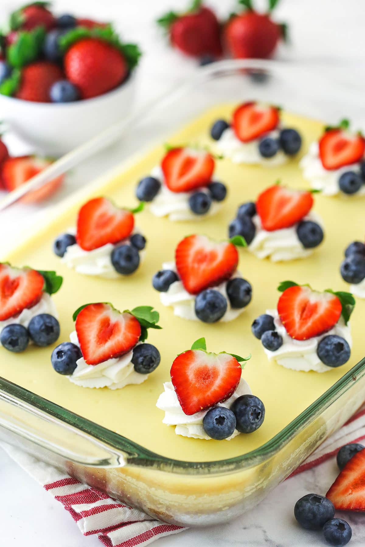 Completed easy cheesecake recipe topped with whipped cream and berries.