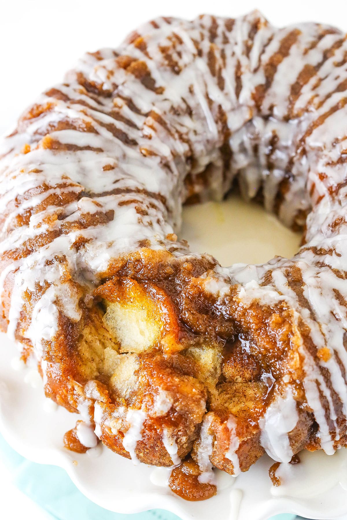 Overhead view of Monkey Bread with a glaze drizzle on a white plate.