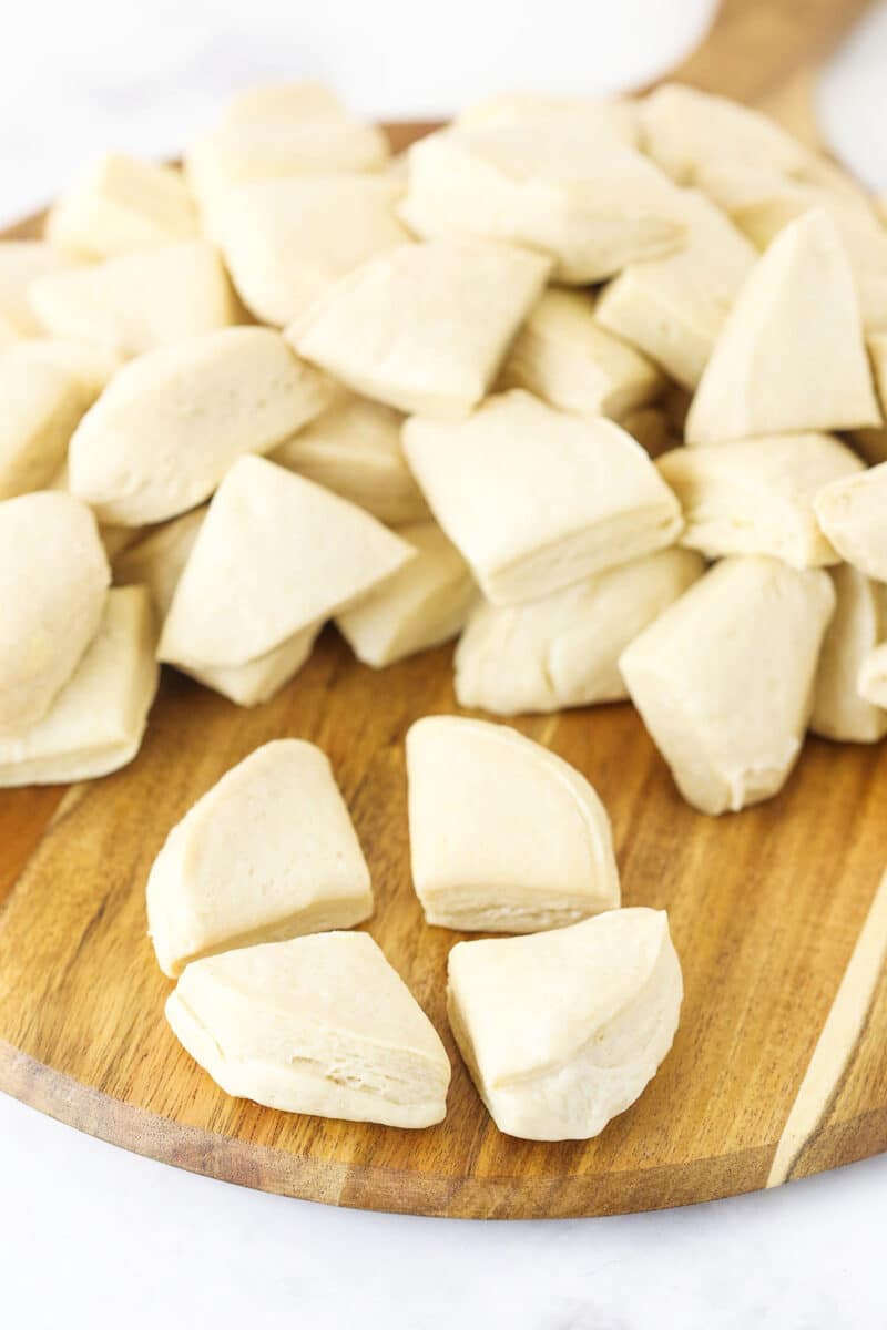 This EASY Monkey Bread recipe is made with balls of refrigerated cookie dough rolled in cinnamon-sugar and coated with brown sugar sauce. Making Monkey Bread Step showing each biscuit being cut into four pieces