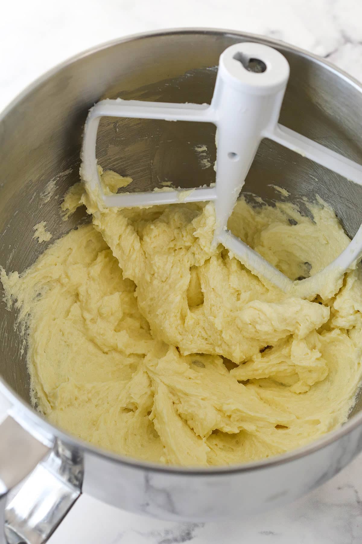 Beating eggs and vanilla into sugar cookie dough.