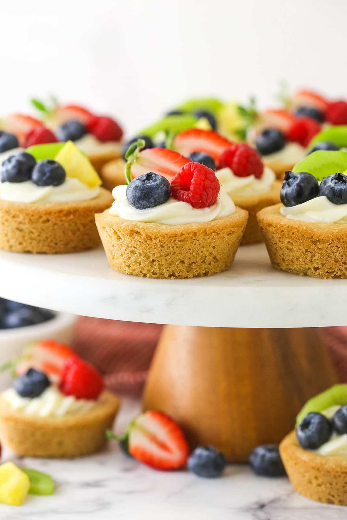 Easy fruit cheesecake sugar cookie cups arranged on a cake platter.