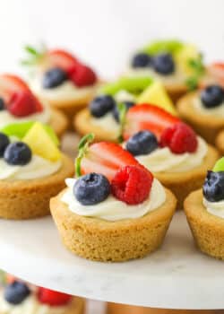 Easy fruit cheesecake sugar cookie cups arranged on a cake platter.