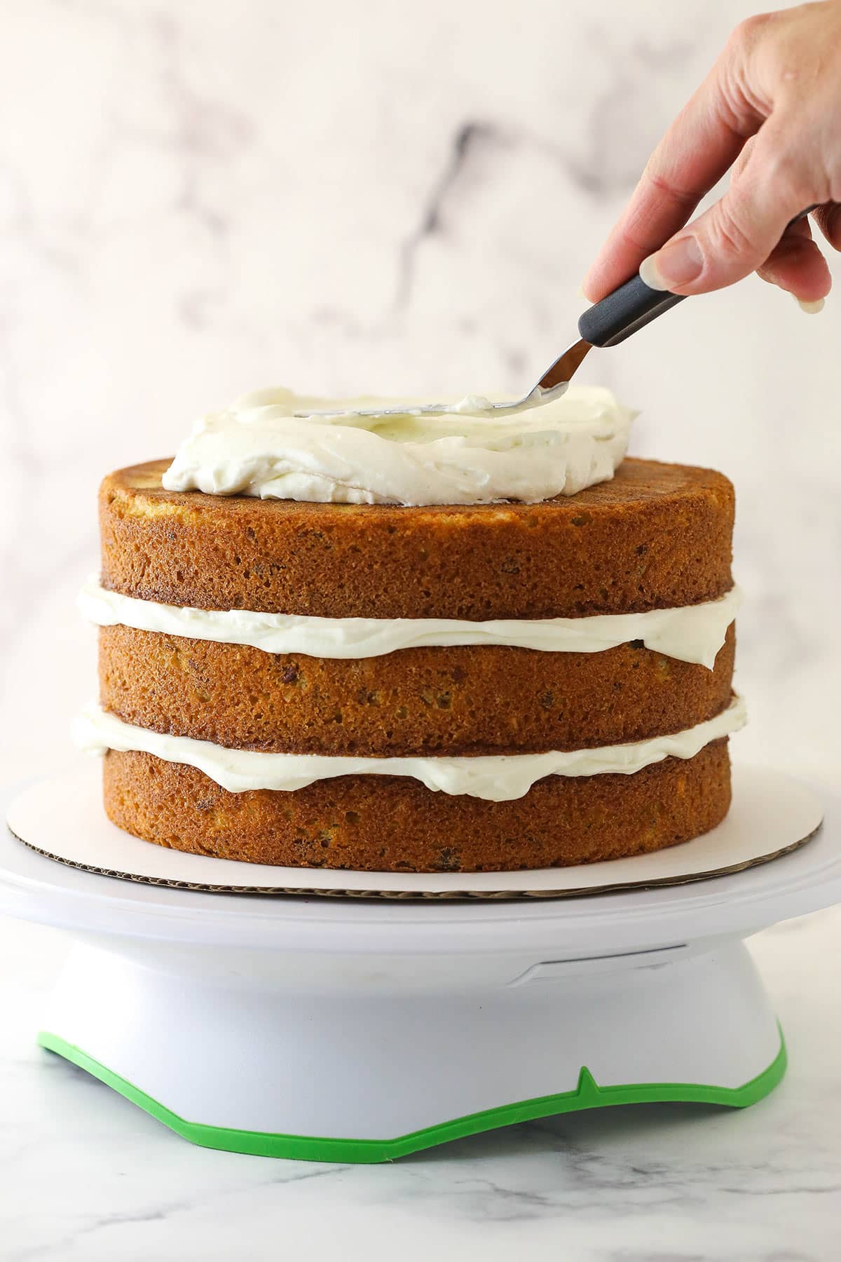 Stacking and frosting layers for Italian cream cake.