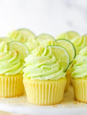Side view of Key Lime Coconut Cupcakes on a cake stand