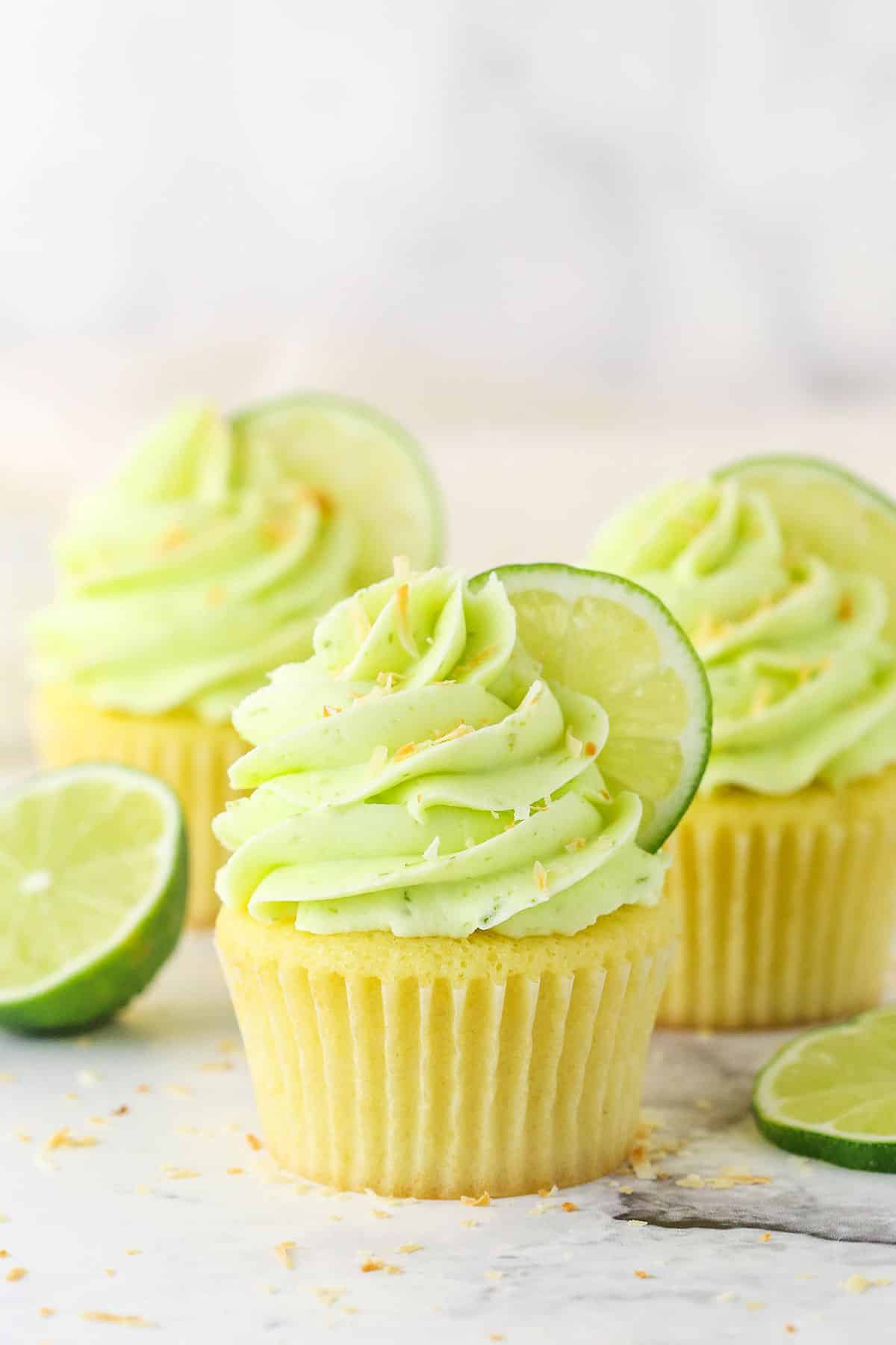 Side view of three Key Lime Coconut Cupcakes