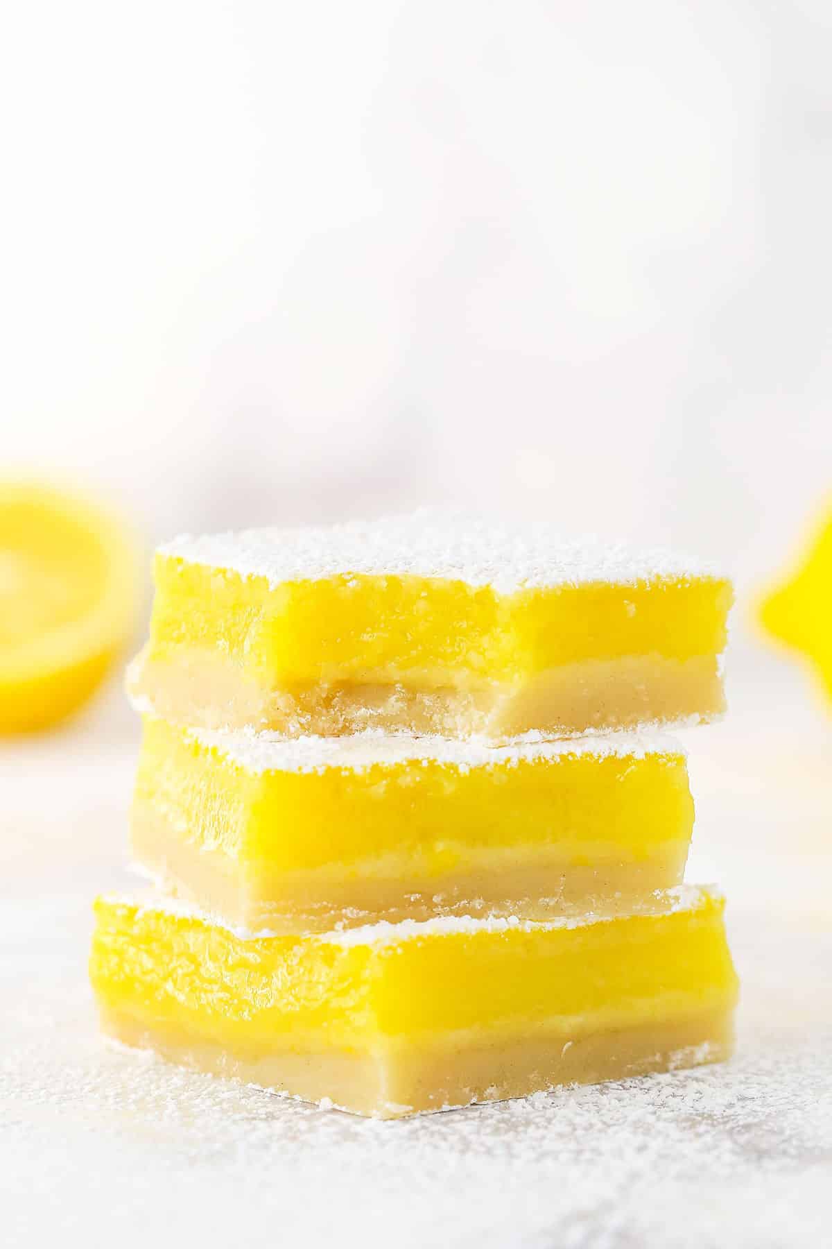 A stack of three Lemon Bars with the top one missing a bite