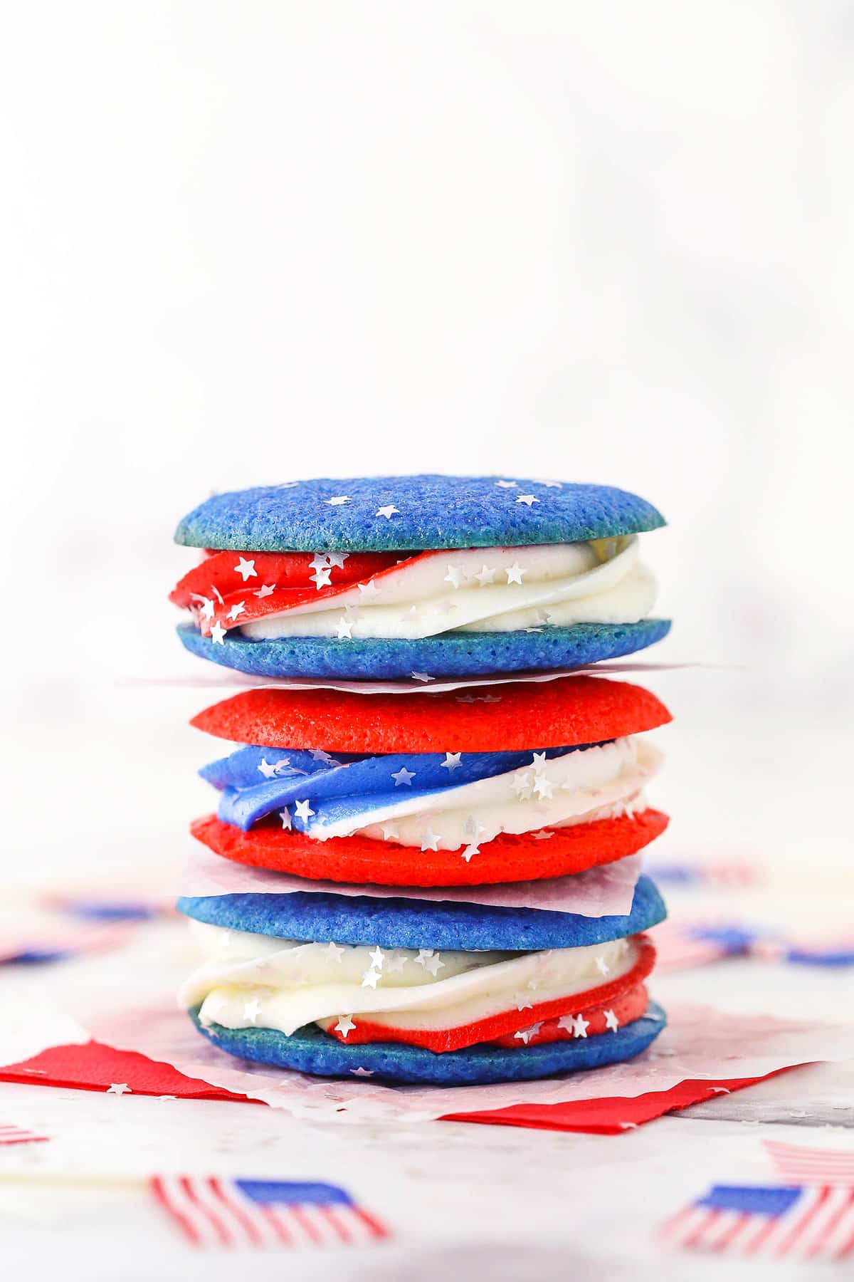 These Red, White and Blue Cookie Sandwiches are perfect for any patriotic holiday! With July 4th approaching in a couple weeks, these should definitely be on your list of things to make. They are easy, festive and delicious! red, white and blue cookie sandwiches in a stack of three