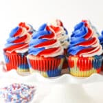 close up of red, white and blue cupcakes on a cake stand