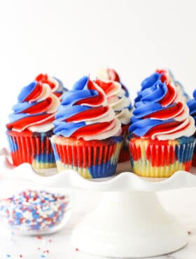 close up of red, white and blue cupcakes on a cake stand