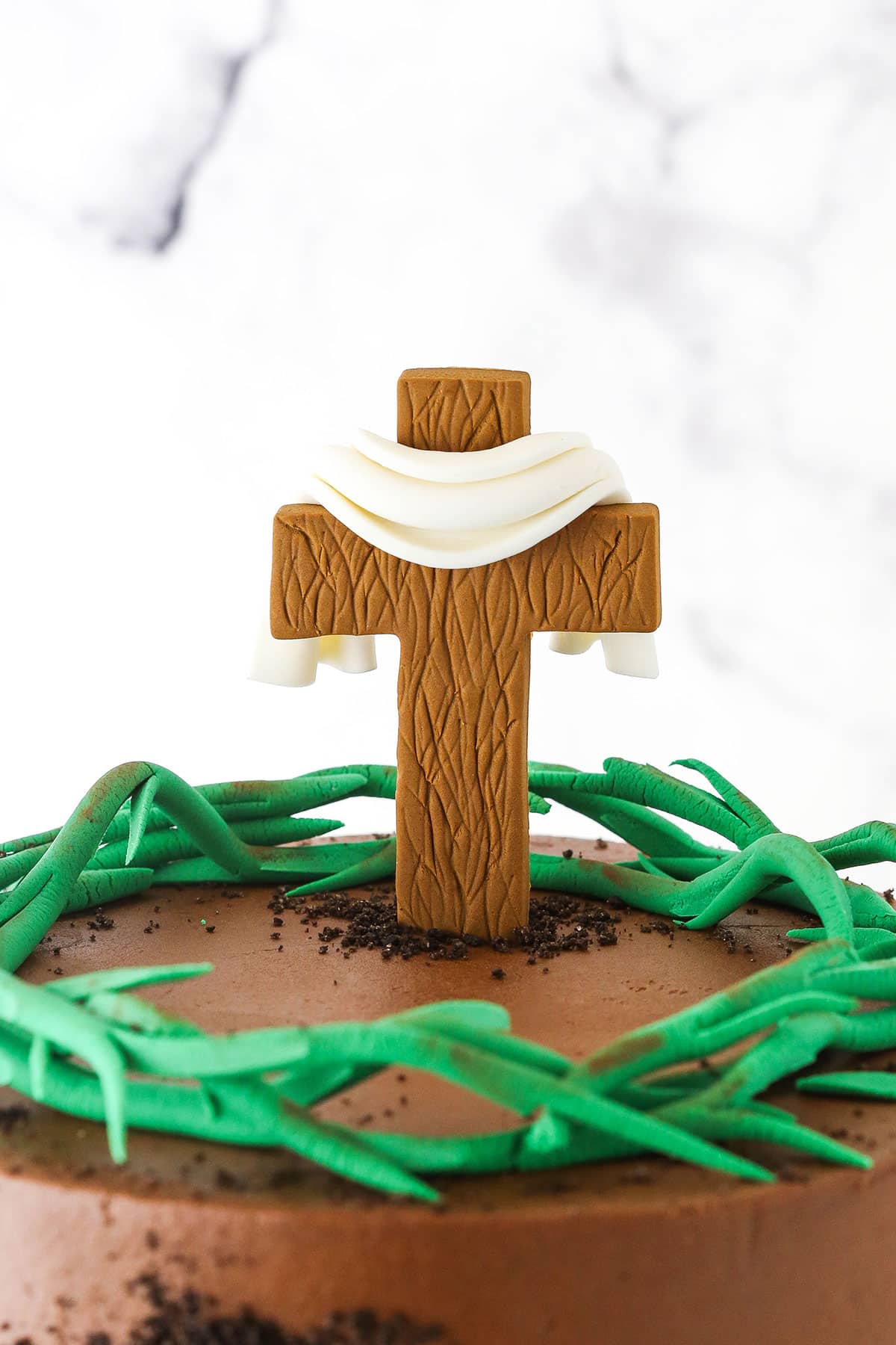 A closeup view of the decorated top of a Resurrection Cake with a cross and crown of thorns