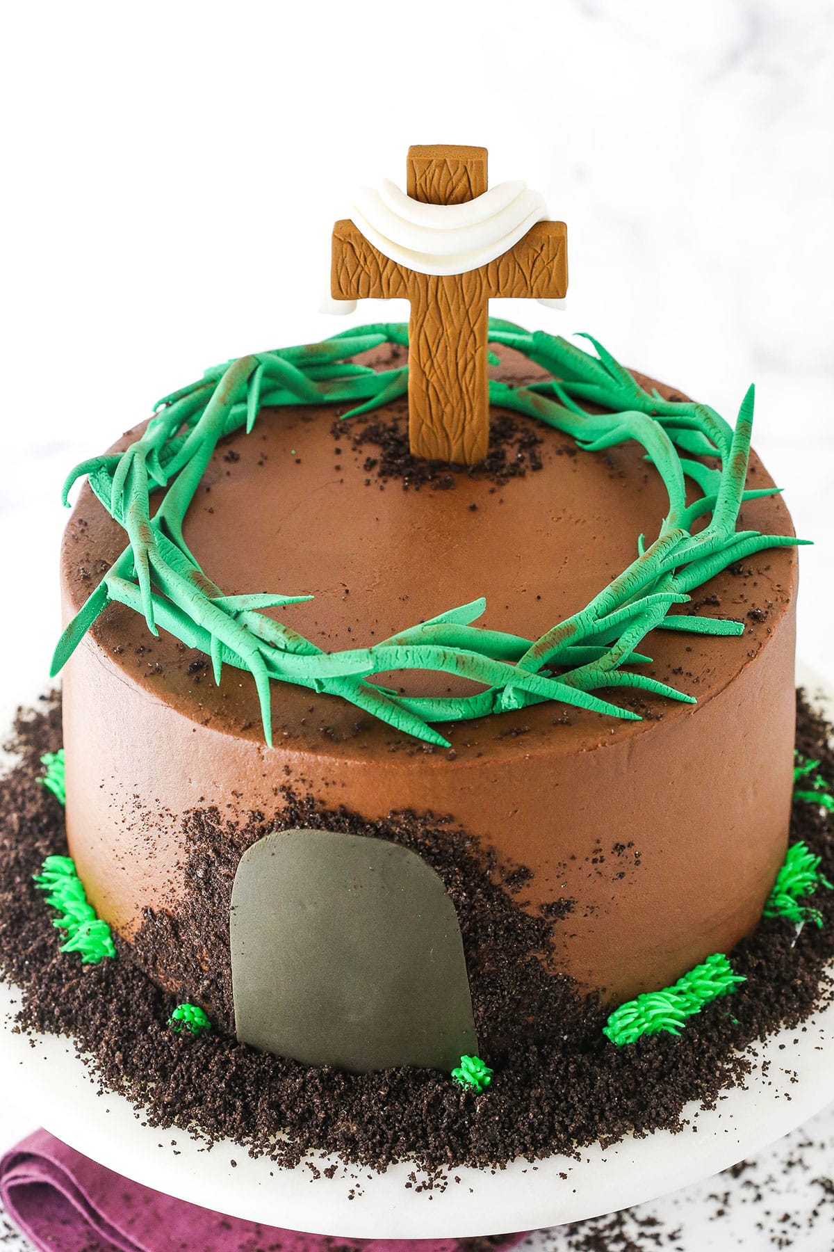 Side view of a Resurrection Cake decorated with a fondant cross and crown of thorns