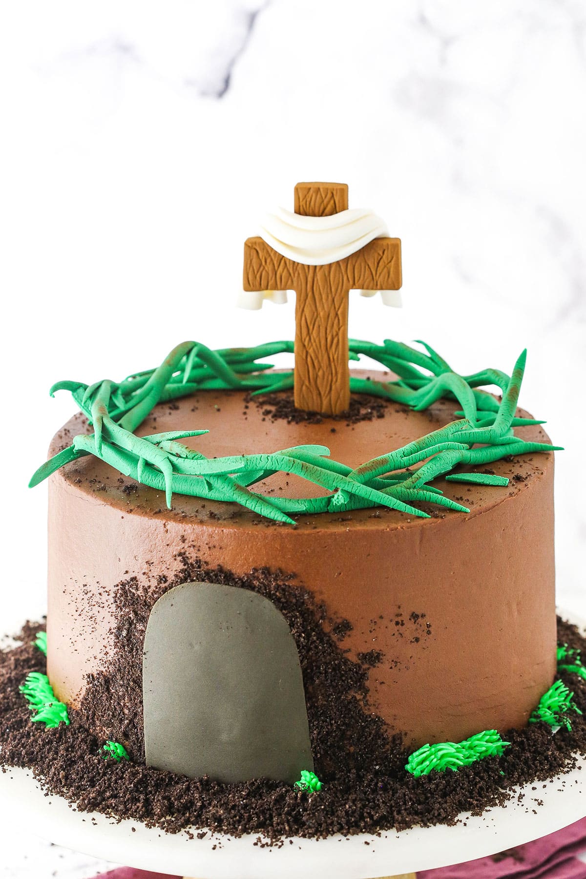 Side view of a Resurrection Cake decorated with a fondant cross and crown of thorns