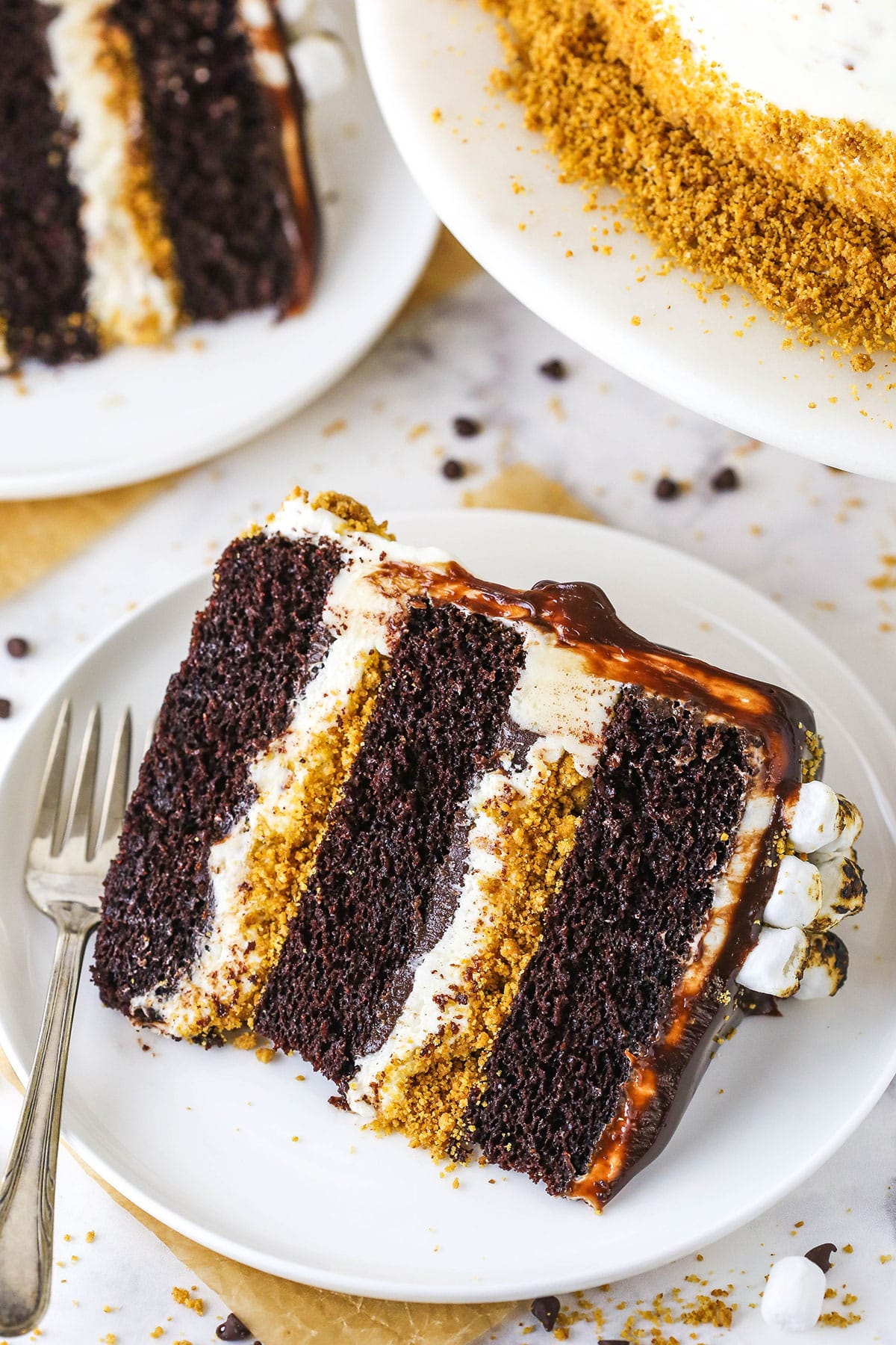 A slice of S'mores Cake with a fork on a white plate