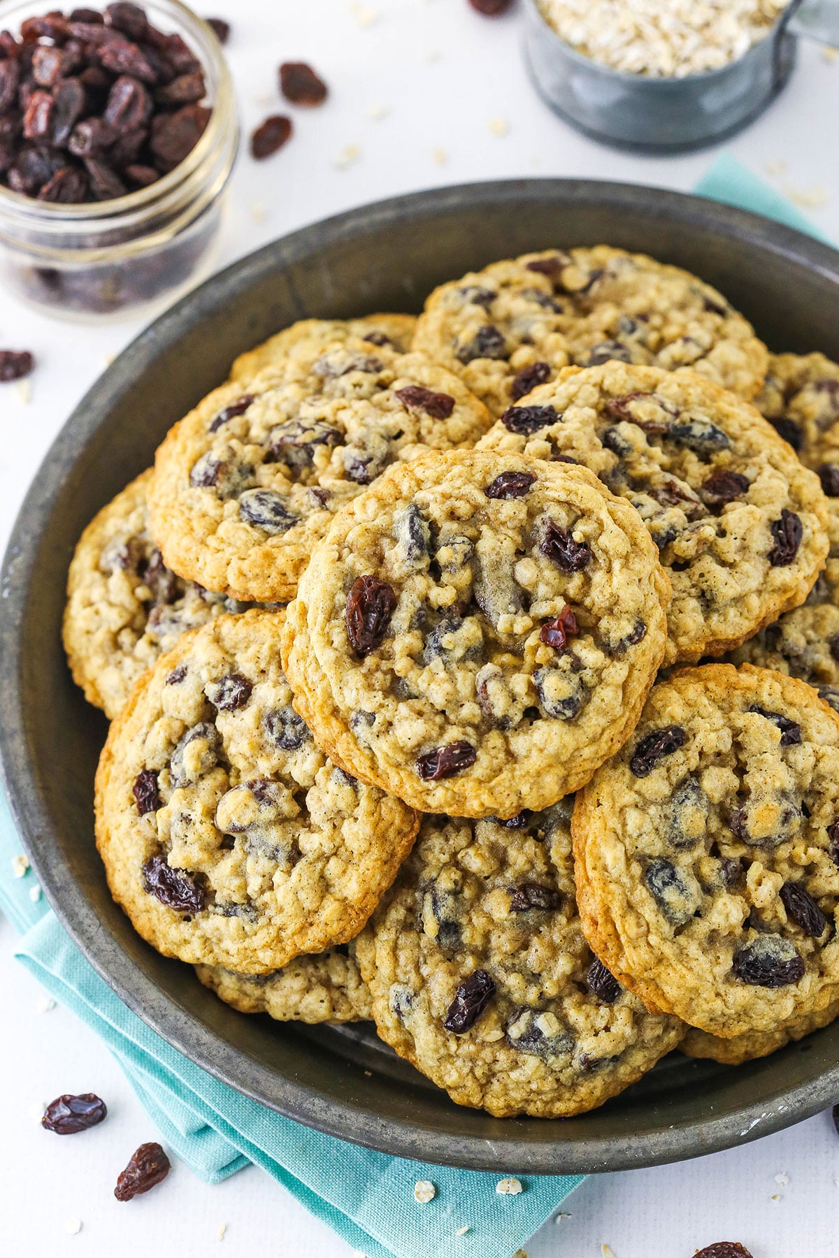 Overhead view of a grey plate stacked with homemade oatmeal raisin cookies.
