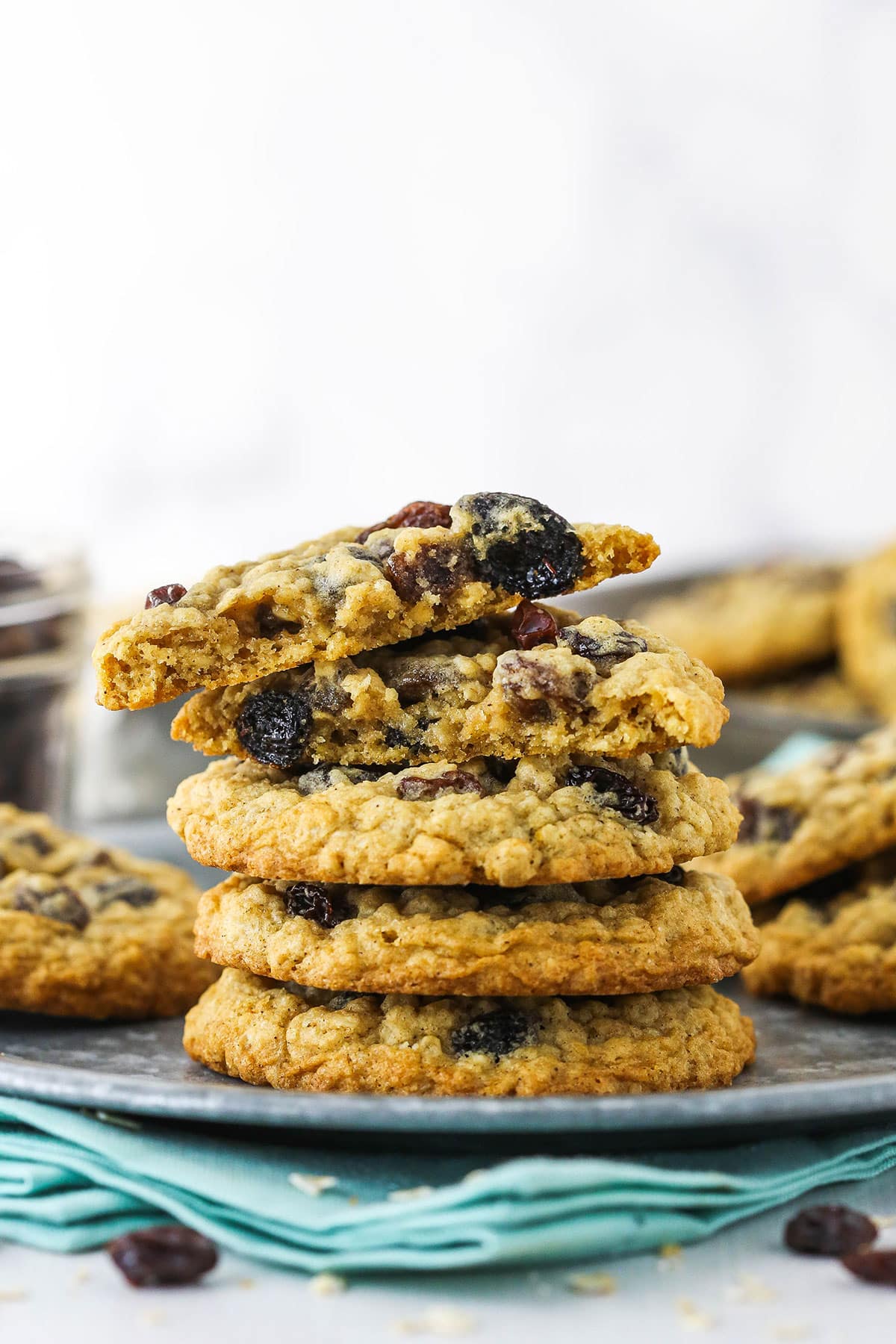 Soft, chewy oatmeal raisin cookies are perfect for dunking in milk and loaded with oats and raisins. Everyone will love these classic cookies! Side view showing a stack of oatmeal raisin cookies on a plate.