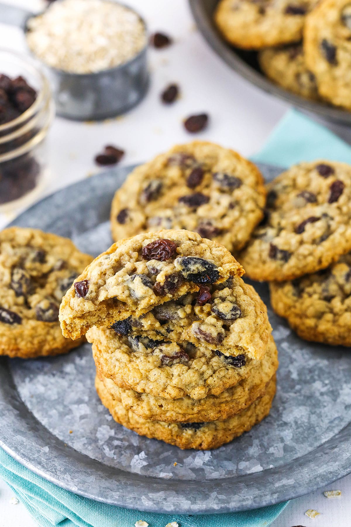 Top view showing a stack of oatmeal raisin cookies on a plate with the top cookie broken in half