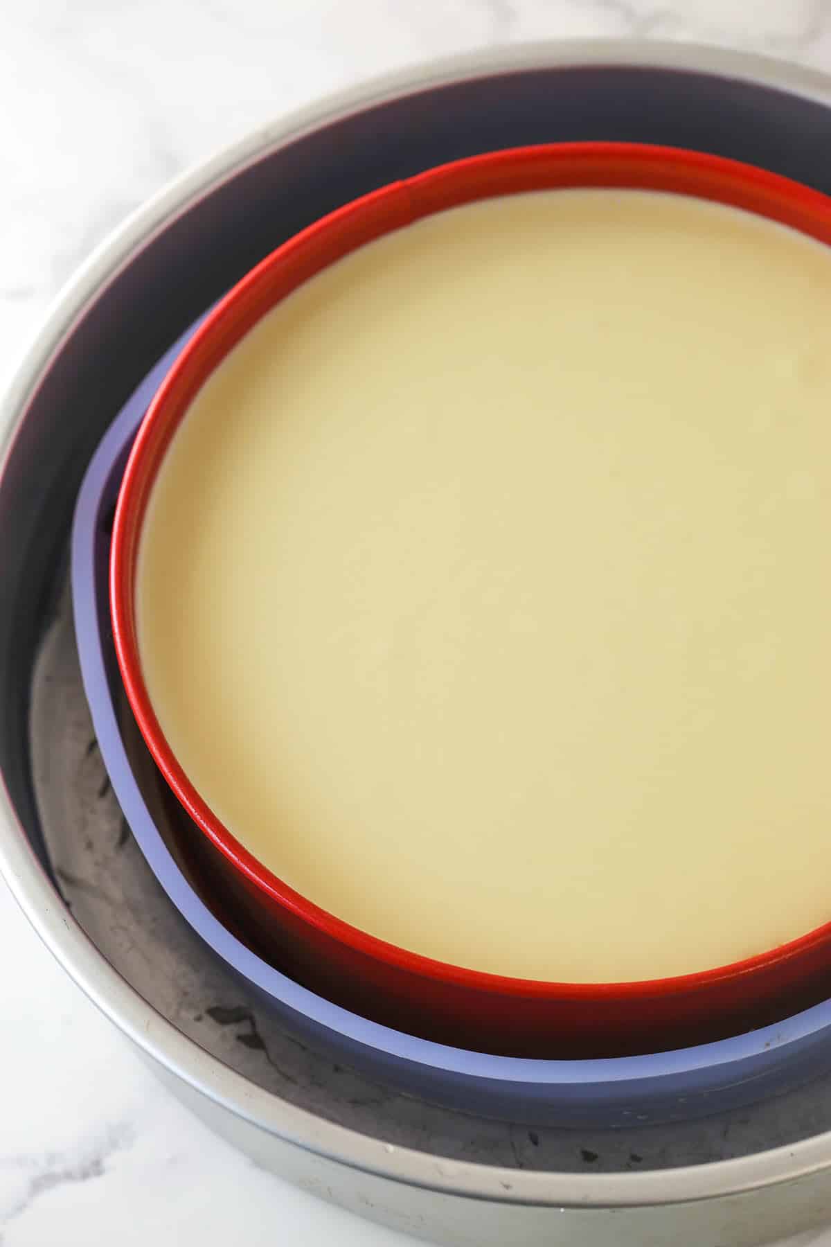 This perfect-for-summer strawberry cheesecake is made of a Graham Cracker crust, a creamy cheesecake filling, and a sweet strawberry sauce. Cheesecake in a springform pan ready to be baked.