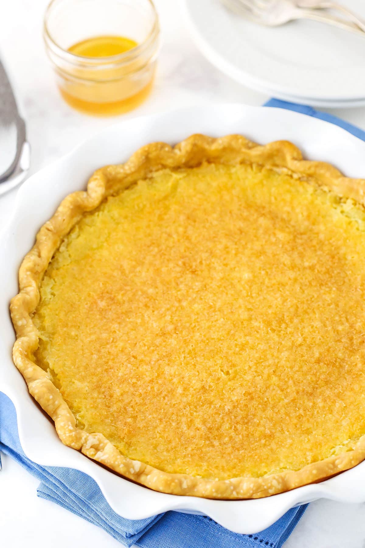 Overhead view of a full Vinegar Pie in a white platter on a blue place mat