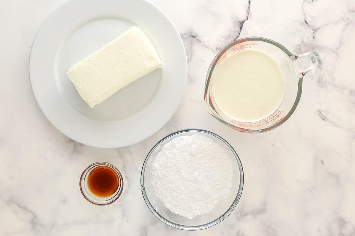 Ingredients for whipped cream cheese frosting separated into bowls.