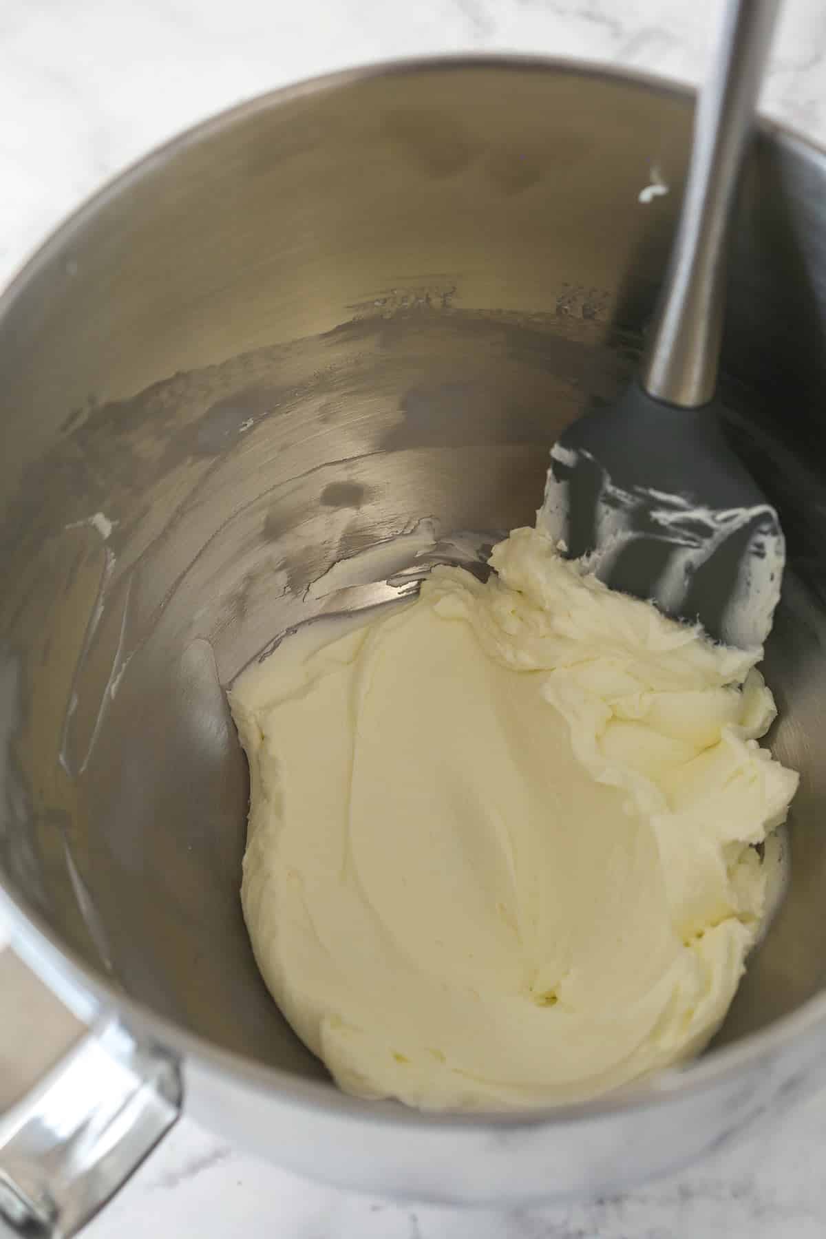Cream cheese in a mixing bowl that has been whipped until smooth and creamy.