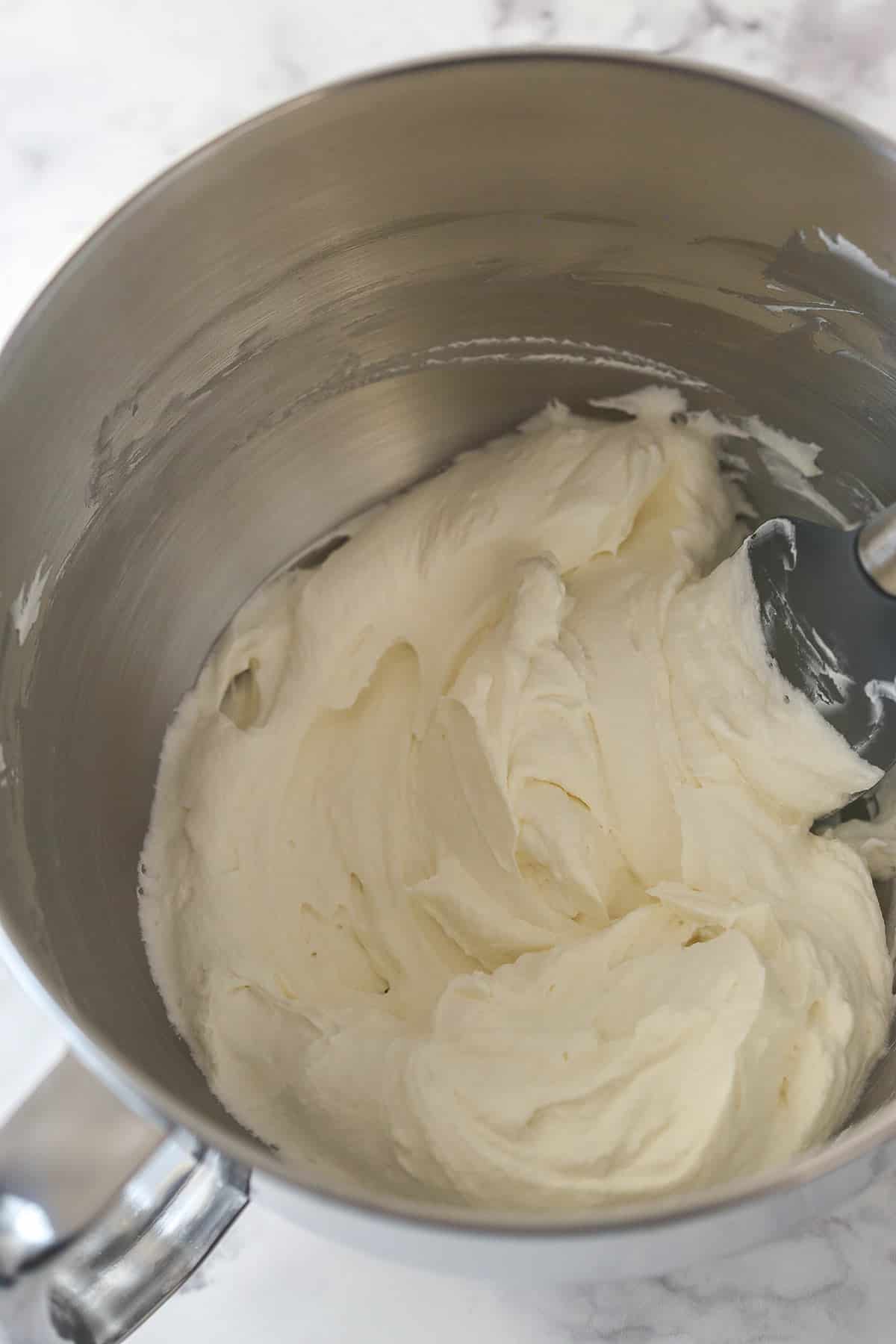 Folding whipped cream into cream cheese.