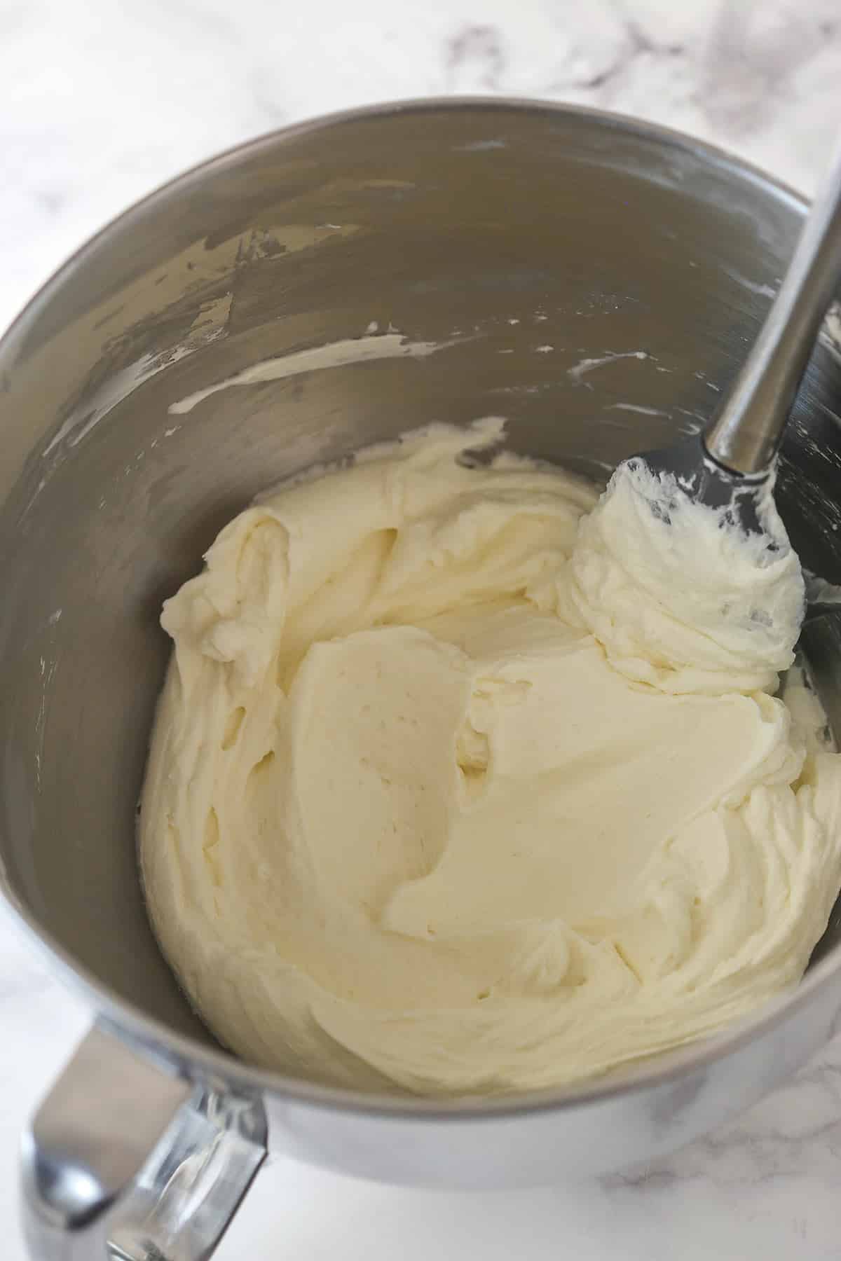 Whipped cream frosting in a mixing bowl.