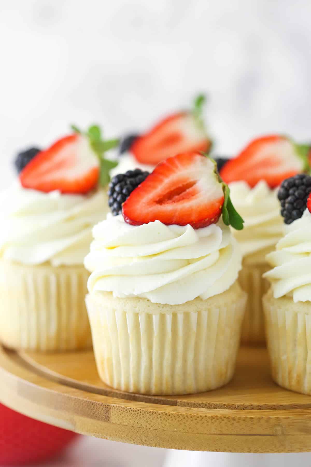 Cupcakes topped with whipped cream frosting and fresh berries.