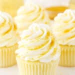 Four Champagne Cupcakes decorated with buttercream frosting on a white table top