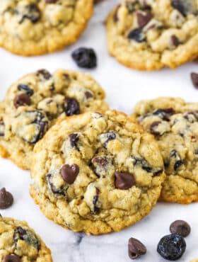 Overhead view of Cherry Chocolate Chip Oatmeal Cookies spread out on a white marble table top.