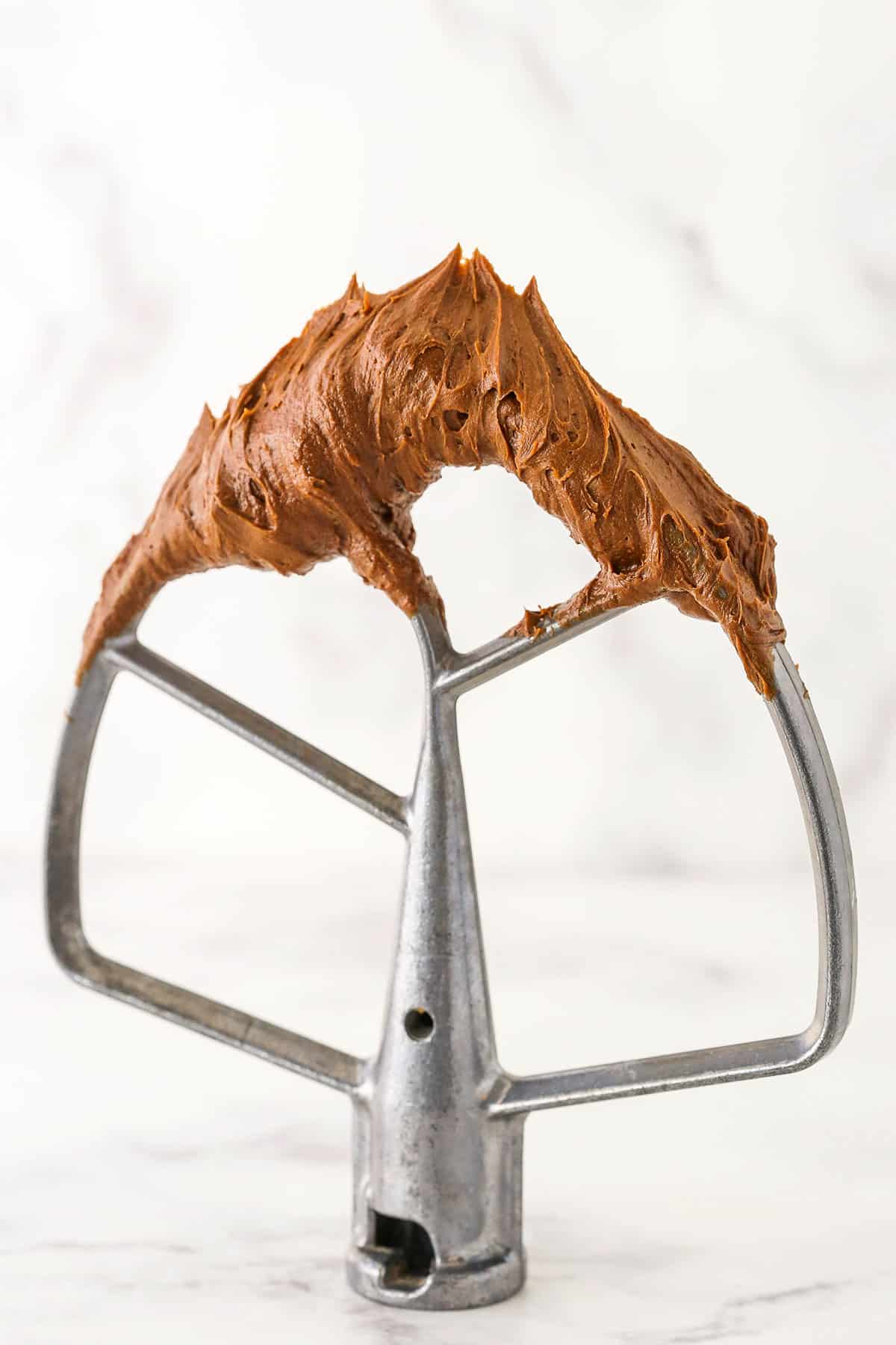 Chocolate Buttercream Frosting on a mixer blade