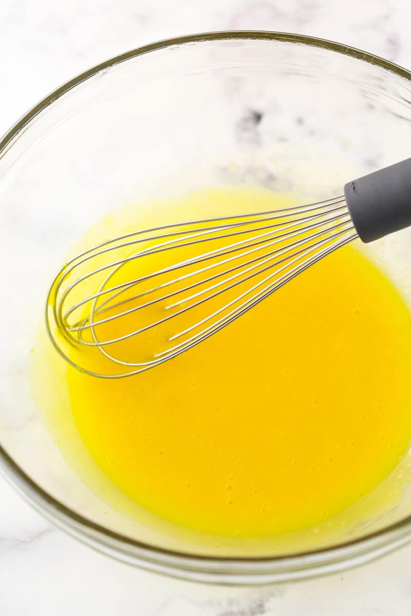 Whisking together egg yolks in a mixing bowl.