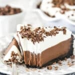 Chocolate cream pie on a plate with a fork taking a bite out of it.