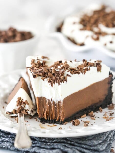 Chocolate cream pie on a plate with a fork taking a bite out of it.