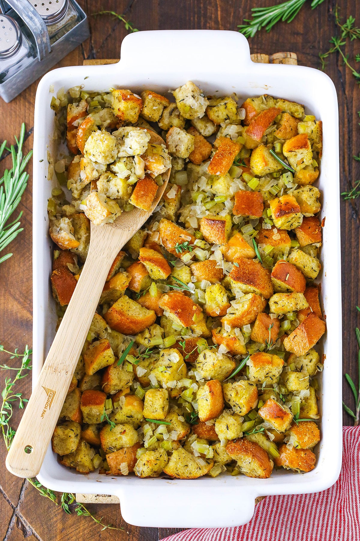 Classic Homemade Stuffing in a white serving platter with a wooden spoon